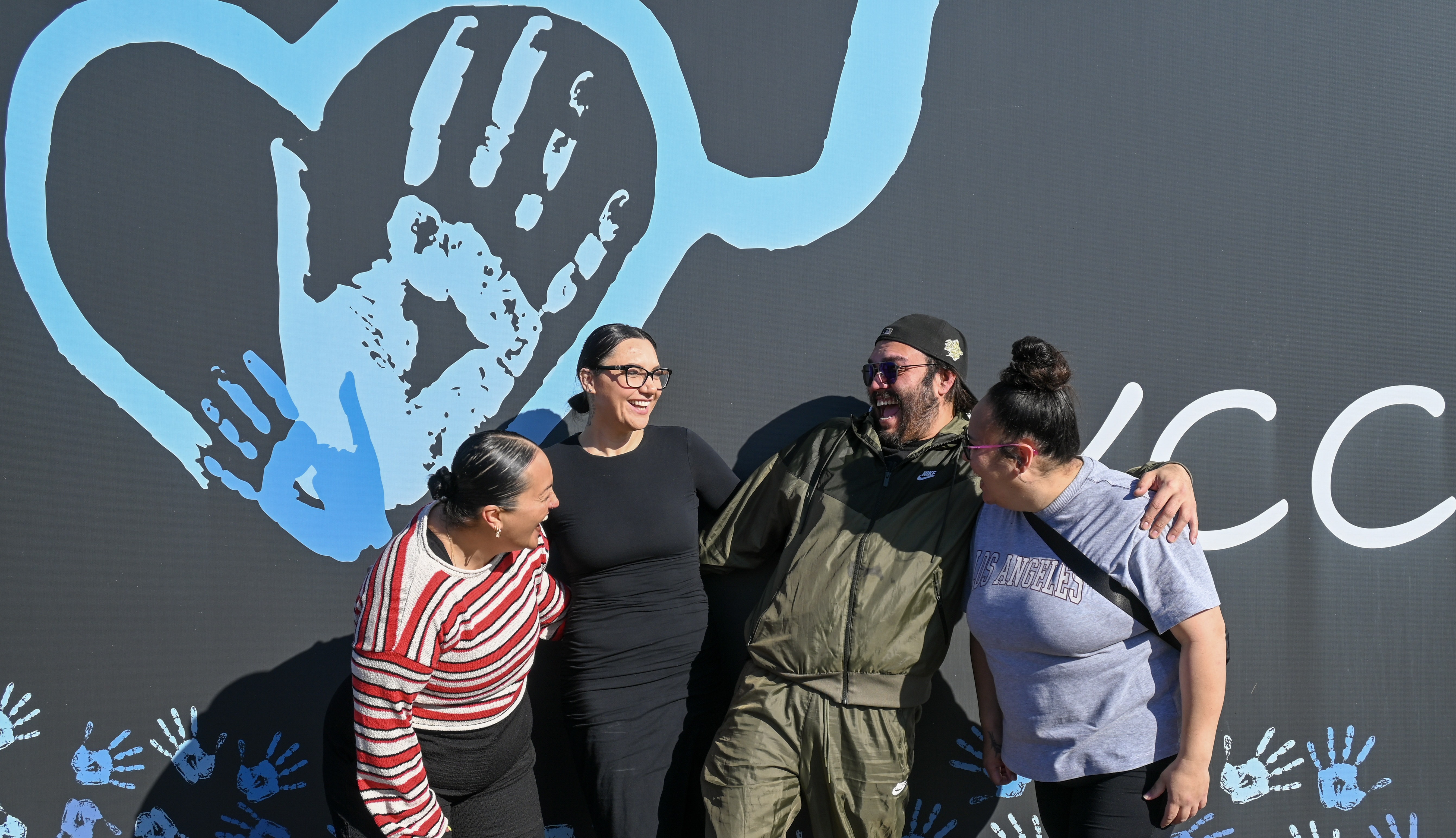 Progressive Youth Care team beside the mural